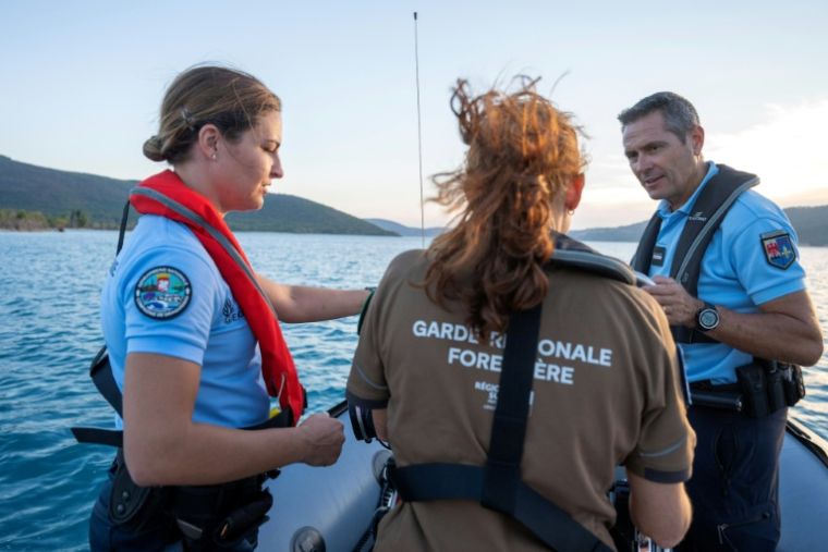 Des gendarmes et une garde forestière lors d'une opération de prévention contre les bivouacs illégaux susceptibles de provoquer un départ de feu, le 8 août 2026 sur le lac de Sainte-Croix, aux portes des Gorges du Verdon ( AFP / Miguel MEDINA )