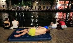 Un jeune se rafraïchit le long du canal Saint-Martin en pleine canicule à Paris le 25 juin 2026 ( AFP / Ludovic MARIN )