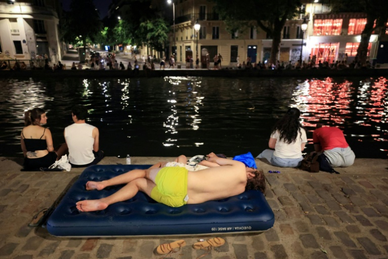 Une personne se rafraîchit au bord du canal Saint-Martin, à Paris, le 25 juin 2026 ( AFP / Ludovic MARIN )