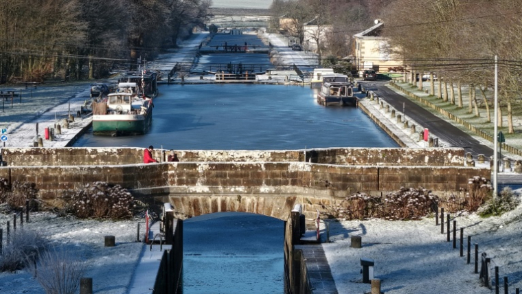 Des péniches sur un canal gelé à Hédé-Bazouges, en Ille-et-Vilaine, le 6 janvier 2026 ( AFP / Damien MEYER )