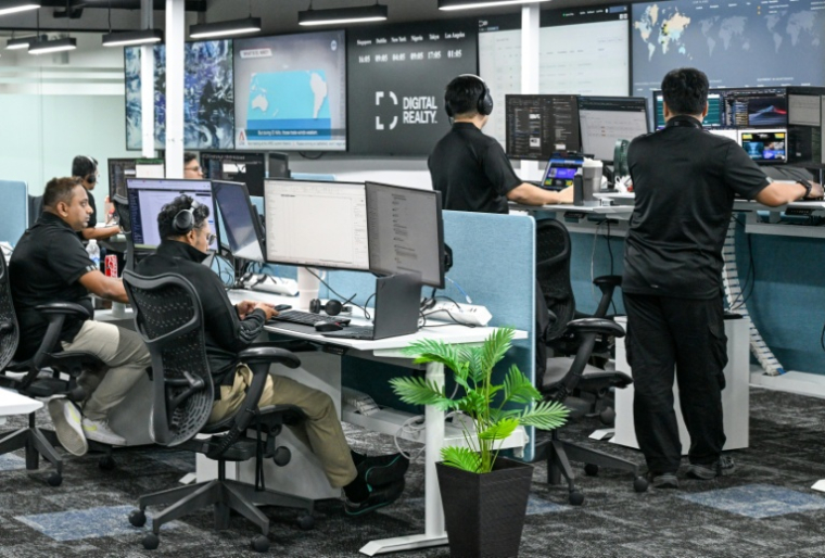 Des analystes au centre de commandement de la société américaine Digital Realty, le 2 septembre 2026 à Singapour  ( AFP / Roslan RAHMAN )