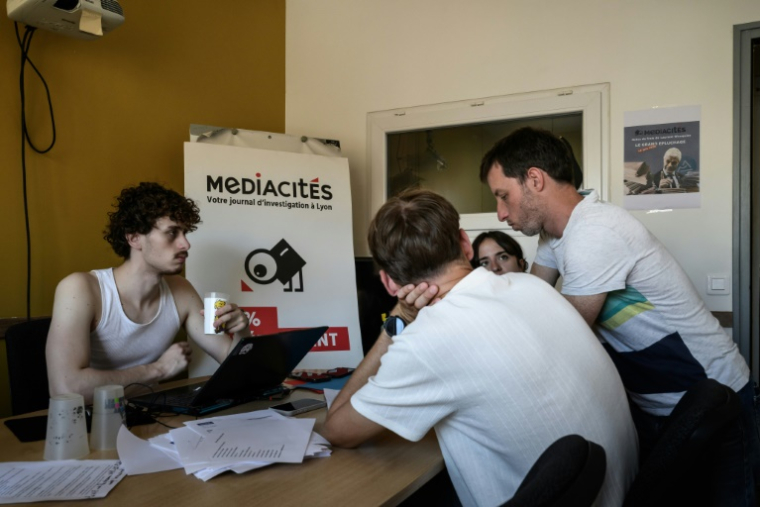 Des journalistes de Mediacités et des bénévoles examinent des notes de frais établies lorsque  Laurent Wauquiez (LR) était président de la région Auvergne-Rhône-Alpes, dans les locaux de Mediacités à Lyon, le 18 juin 2026 ( AFP / Jeff PACHOUD )