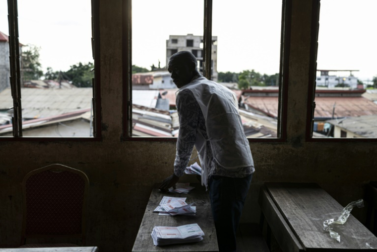 Un employé de la Direction générale des élections de Guinée (DGE) procède au comptage des voix le 21 septembre 2025 d'un bureau de vote situé dans l'école primaire de Taouyah, dans la capitale Conakry. Quatre ans après la prise de pouvoir des militaires, la junte a soumis au vote un projet de nouvelle Constitution  ( AFP / PATRICK MEINHARDT )