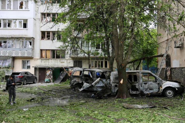 Des voitures détruites dans la cour d'un immeuble résidentiel endommagé par une attaque de drone à Odessa, le 13 mai 2026 en Ukraine ( AFP / Oleksandr GIMANOV )