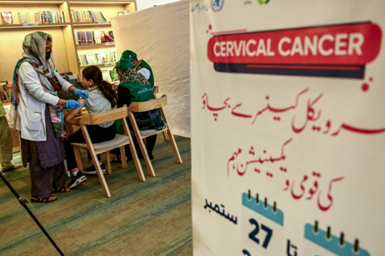 Une soignante (g) administre le vaccin contre le virus du papillome humain (VPH) à une adolescente, lors d'une campagne de vaccination contre le cancer du col de l'utérus, le 24 septembre 2025 à Karachi, au Pakistan ( AFP / Rizwan TABASSUM )