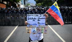 Une femme manifeste pour de meilleures retraites et conditions de travail, à Caracas, le 1er mai 2026 ( AFP / Federico PARRA )