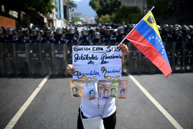 Une femme manifeste pour de meilleures retraites et conditions de travail, à Caracas, le 1er mai 2026 ( AFP / Federico PARRA )