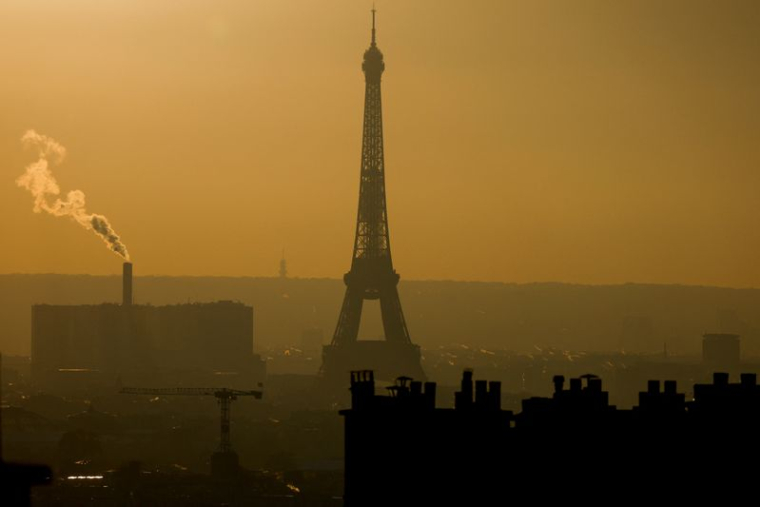 Une vue d'ensemble montre la Tour Eiffel et la vapeur qui s'échappe des cheminées dans l'horizon de Paris