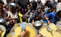 Des Palestiniens reçoivent de la soupe aux lentilles à un point de distribution de nourriture dans la ville de Gaza, le 1er août 2025 ( AFP / Omar AL-QATTAA )
