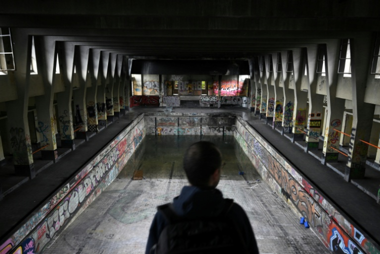 Un explorateur urbain (urbex) devant une ancienne piscine à l'abandon à Charleroi, dans le sud de la Belgique, le 11 mars 2026 ( AFP / Nicolas TUCAT )