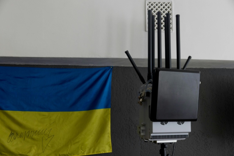 Un brouilleur antidrone à côté d'un drapeau ukrainien, dans une entreprise de fabrication de brouilleurs, à Kiev le 7 mai 2026, en Ukraine ( AFP / Tetiana DZHAFAROVA )