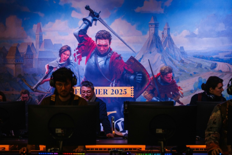 Des visiteurs jouent au jeu vidéo "Kingdom Come: Deliverance II" de Warhorse Studios lors d'une avant-première presse au salon "Paris Games Week" à Paris, le 22 octobre 2024 ( AFP / Dimitar DILKOFF )