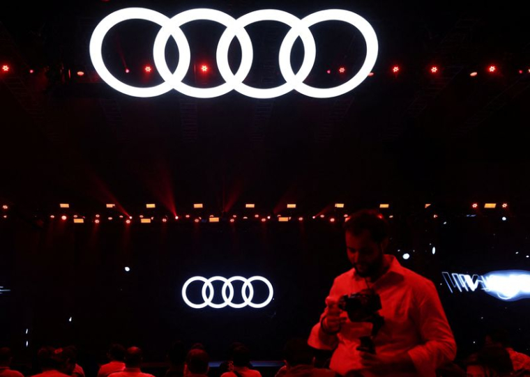 Un homme passe devant un logo du constructeur automobile allemand Audi