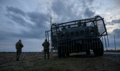 Des soldats ukrainiens devant un véhicule militaire blindé entouré d'une cage de protection contre les attaques de drones, sur une route près d'Oleksandrivka, le 6 octobre 2025 ( AFP / Ed JONES )