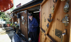 Peter McLaughlin à l'entrée de son abri de jardin, aménagé pour reproduire la chaufferie d'un navire, à l'arrière de sa maison à Londres, le 31 juillet 2026 ( AFP / Henry NICHOLLS )