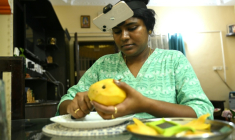 Nagireddy Sriramyachandra filme avec un téléphone ses gestes pendant qu'elle coupe une mangue pour entraîner un futur robot dopé à l'IA, le 15 mai 2026 à Madras, en Inde ( AFP / R.Satish BABU )
