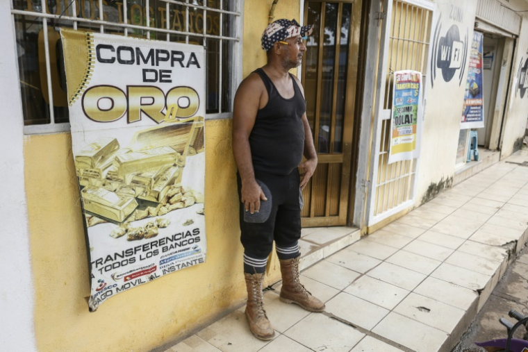 Un mineur devant une boutique d'achat d'or dans la ville minière d'El Dorado, dans l'Etat de Bolivar, le 24 mai 2025 au Venezuela ( AFP / Pedro MATTEY )