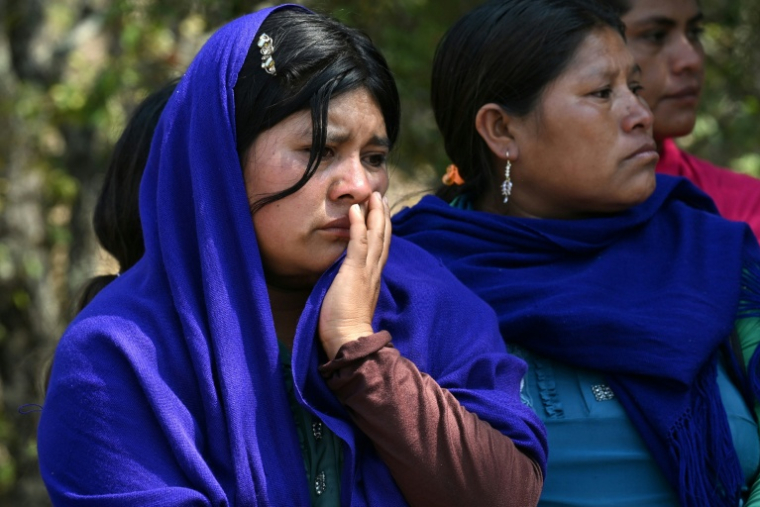 Des femmes indigènes nahuas pleurent lors des funérailles de membres d'un groupe d'autodéfense après une attaque perpétrée par de présumés membres du cartel de la drogue Los Ardillos, à Alcozacan, dans l'Etat de Guerrero, au Mexique, le 20 mai 2026 ( AFP / YURI CORTEZ )