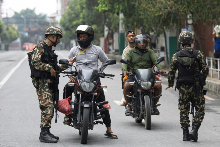 Des militaires contrôlent les pièces d'identité et documents de motocyclistes dans le cadre des mesures de sécurité imposées à Katmandou, le 10 septembre 2025 au Népal ( AFP / PRABIN RANABHAT )