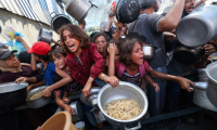 Des enfants palestiniens se bousculent pour recevoir un repas chaud à Nousseirat, dans la bande de Gaza, le 4 septembre 2025 ( AFP / Eyad BABA )