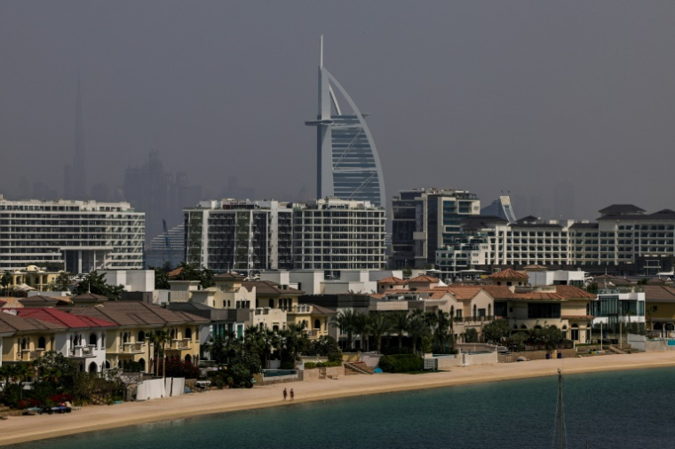 Deux personnes marchent sur une plage de Palm Jumeirah à Dubaï, le 2 mars 2026 ( AFP / Fadel SENNA )