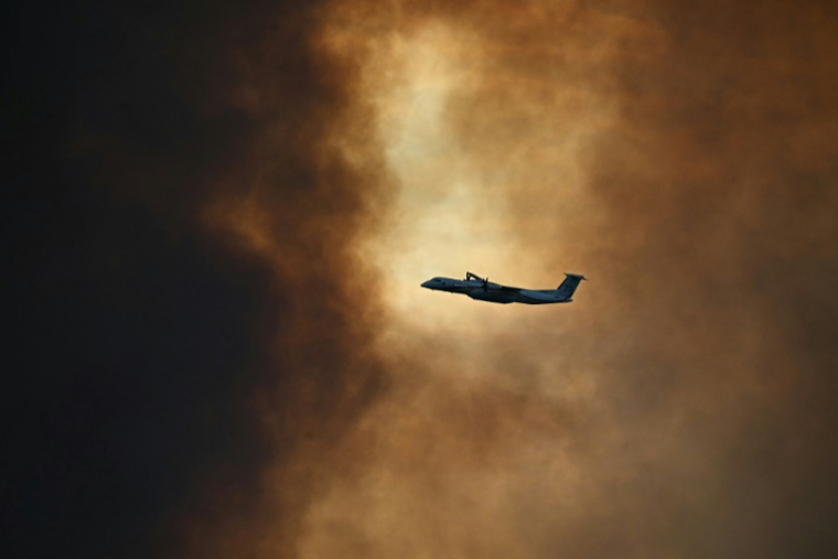 Un bombardier Dash participe à la lutte contre un incendie au-dessus de Fontjoncouse dans l'Aude le 6 août 2025 ( AFP / Lionel BONAVENTURE )