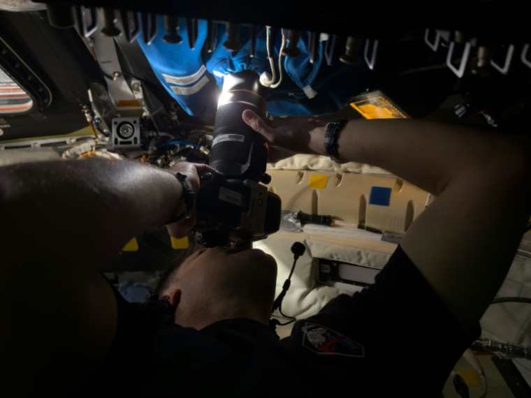 Photo diffusée le 7 avril 2026 par la Nasa montrant l'astronaute canadien Jeremy Hansen prenant des images à travers un cache-caméra recouvrant la fenêtre 2 du vaisseau spatial Orion, le 6 avril 2026 ( NASA / Handout )