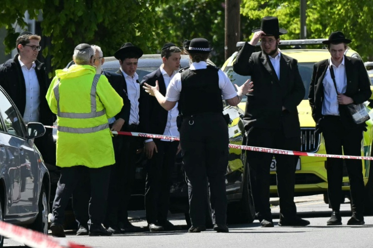 Des habitants derrière un périmètre de sécurité établi dans le quartier de Golders Green, au nord de Londres, le 29 avril 2026, après l'agression au couteau de deux personnes ( AFP / JUSTIN TALLIS )