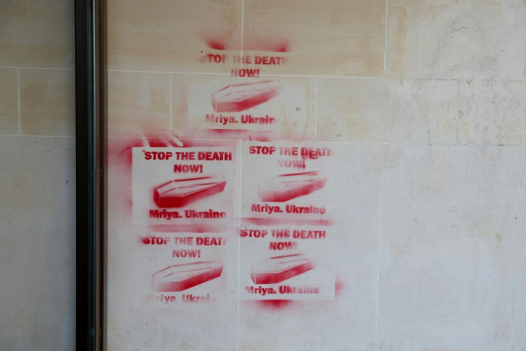 Des cercueils tagués au pochoir sur un mur de l'AFP à Paris le 20 juin 2024 ( AFP / Alain JOCARD )
