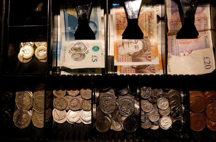 Des billets et pièces en livres sterling dans une caisse