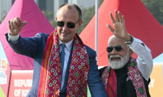 Le Premier ministre indien Narendra Modi (d) et le chancelier allemand Friedrich Merz saluent la foule à leur arrivée au Festival international de cerfs-volants d'Ahmedabad, le 12 janvier 2026 ( AFP / Shammi MEHRA )