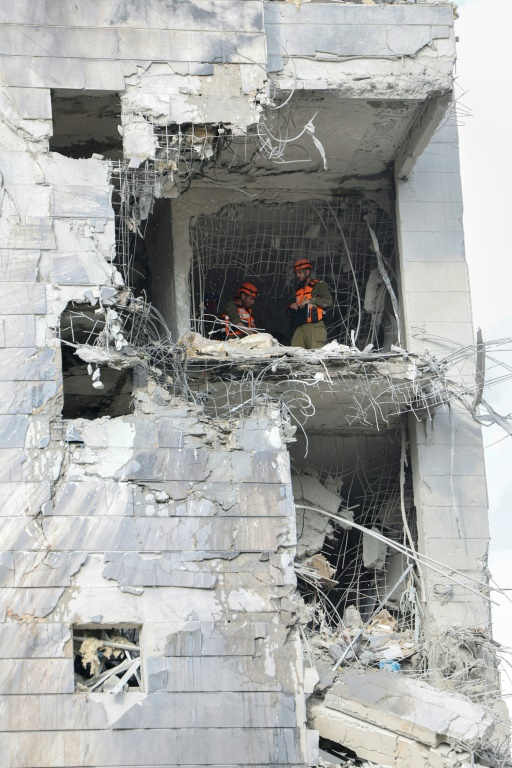 Des secouristes inspectent un bâtiment endommagé à la suite d’une frappe de missile iranien dans la ville israélienne de Petah Tikva, à l’est de Tel-Aviv, le 16 juin 2025 ( AFP / Jack GUEZ )