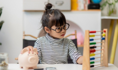 Une petite fille économise pour plus tard. (Crédits: Adobe Stock)