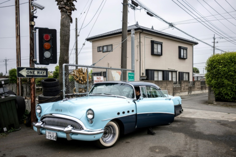 Yosuke Fukuda,p ropriétaire du concessionnaire automobile américain Y-Tech, au volant d'une Buick Roadmaster 1954 à Fukaya, dans la préfecture de Saitama, le 25 avril 2025 au Japon ( AFP / Philip FONG )