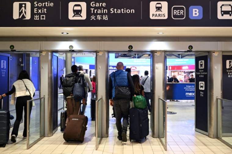 Des passagers à l'aéroport de Roissy-Charles de Gaulle le 18 octobre 2024 ( AFP / BERTRAND GUAY )