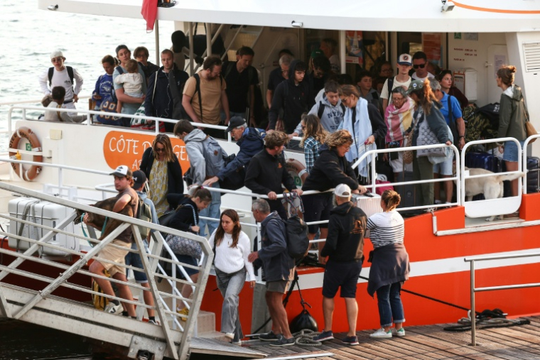 Des vacanciers évacués de Lège-Cap-Ferret, en Gironde, arrivent à Arcachon le 24 juillet 2026  ( AFP / ROMAIN PERROCHEAU )