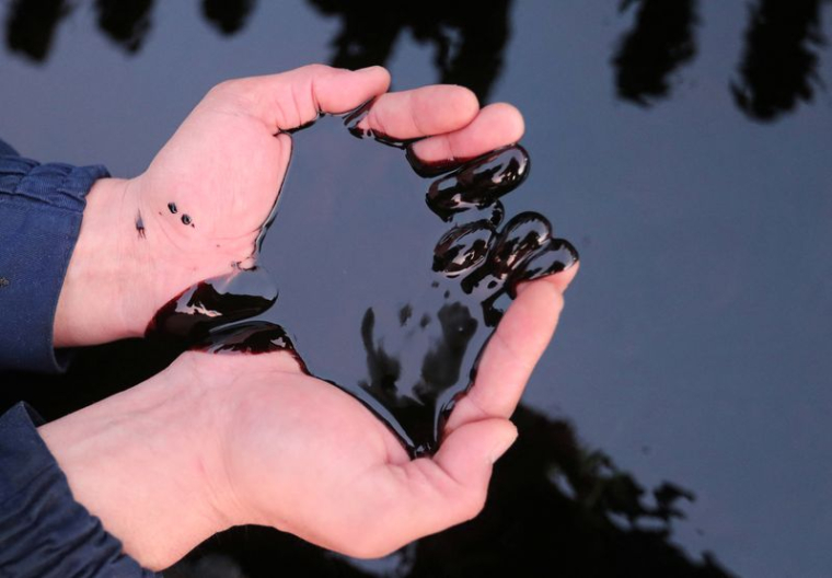 Un homme prend du pétrol dans ses mains