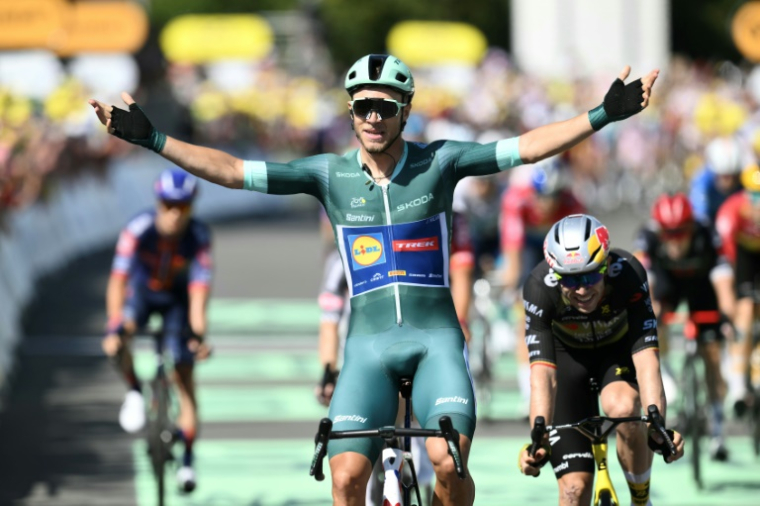 L'Italien Jonathan Milan s'impose au sprint devant le Belge Wout Van Aert, à l'arrivée de la 8e étape à Laval, le 12 juillet 2025 ( AFP / Marco BERTORELLO )
