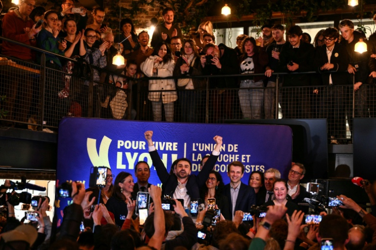 Le maire écologiste sortant de Lyon et candidat à sa réélection, Grégory Doucet (c), célèbre sa victoire au 2e tour des municipales, le 22 mars 2026 à Lyon, dans le Rhône ( AFP / JEFF PACHOUD )