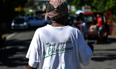 Une femme porte un t-shirt "Tous contre le chlordécone" près d'un barrage routier à La Boucan, localité isolée de Sainte-Rose, en Guadeloupe, le 29 novembre 2021 ( AFP / Christophe ARCHAMBAULT )