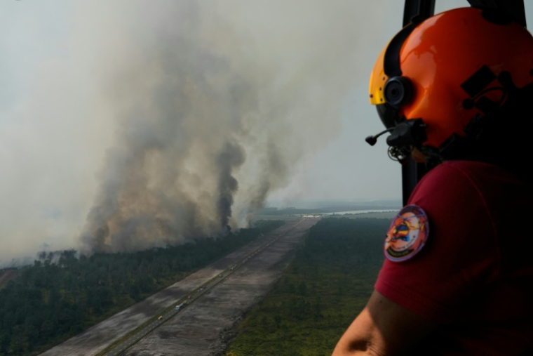 Un hélicoptère de la sécurité civile survole l'incendie d'une près d'Ares (Gironde) le 29 juillet 2026 ( POOL / Baz Ratner )