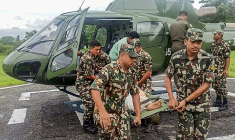 Photo du 5 octobre 2025, prise et diffusée par l'armée népalaise, montrant des militaires transportant une victime évacuée par hélicoptère après des glissements de terrain et des inondations provoqués par de fortes pluies au Népal ( Nepalese Army / - )
