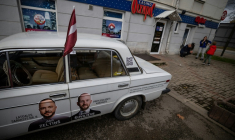 Une voiture ornée de photos des candidats du parti Progresivie (Progressistes) pendant la fête des moissons à Rezekne, en Lettonie, le 27 septembre 2026 ( AFP / Wojtek RADWANSKI )