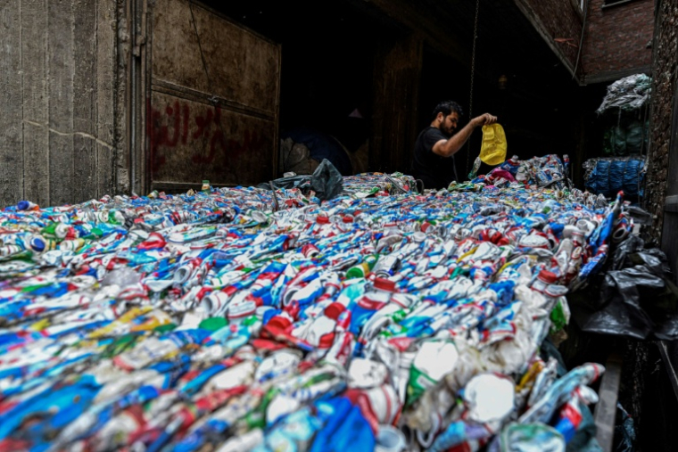 Un ouvrier égyptien conditionne du plastique destiné à être recyclé dans une usine de la "ville des déchets, dans le quartier de Manshiyet Nasser, au Caire le 6 juillet 2026.  ( AFP / Khaled DESOUKI )