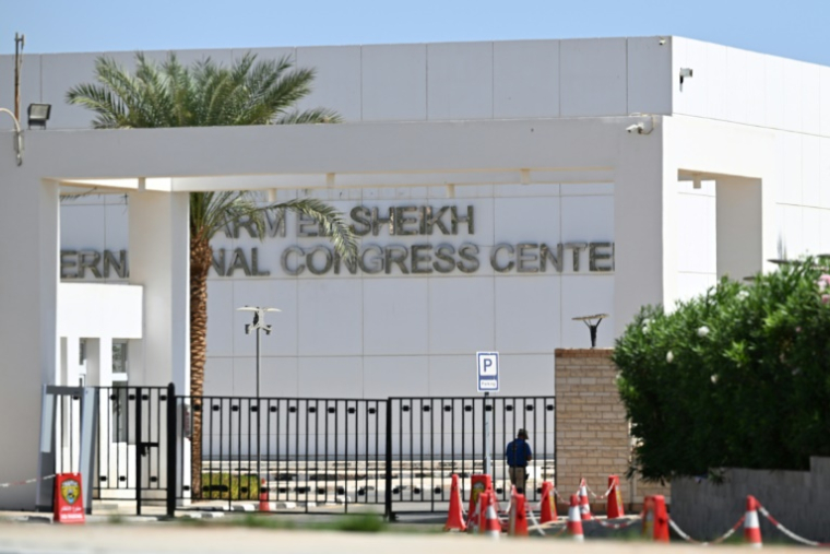 Un homme se tient à l'intérieur du portail du Centre international des congrès à Charm el-Cheikh en Egypte, le 9 octobre 2025, où Israël et le Hamas ont tenu des négociations indirectes ayant abouti à un accord de cessez-le-feu à Gaza ( AFP / Khaled DESOUKI )