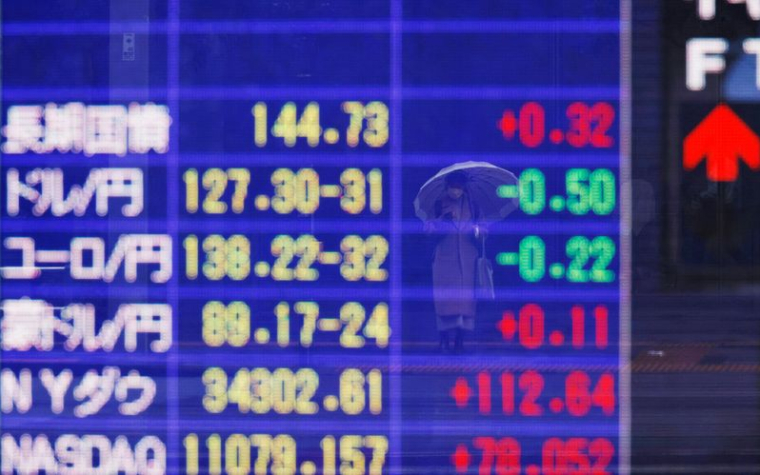 Tableau électrique affichant le niveau des obligations d'État à long terme du Japon et le taux du yen japonais par rapport au dollar américain et à d'autres devises, à l'extérieur d'une maison de courtage à Tokyo
