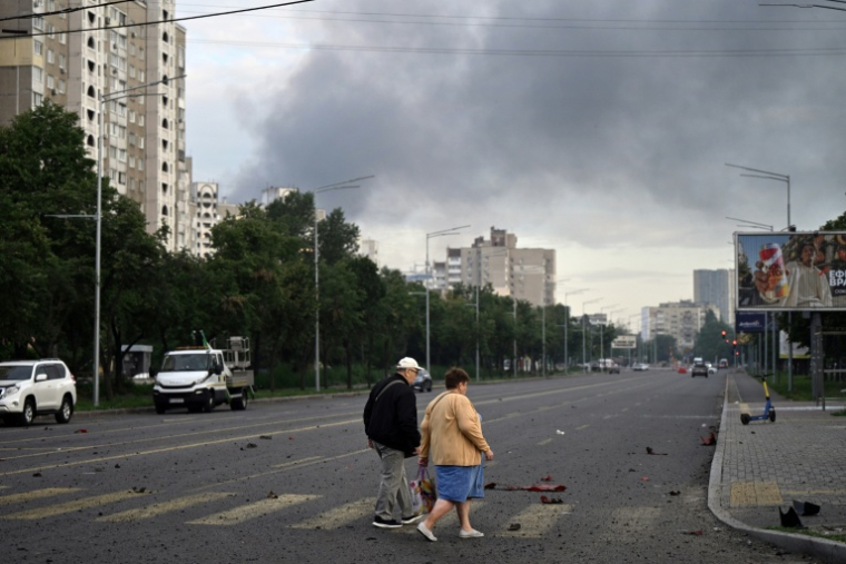Des habitants marchent dans une rue de la capitale de l'Ukraine, Kiev, après une attaque de missiles russes, le 11 juillet 2026 ( AFP / Genya Savilov )