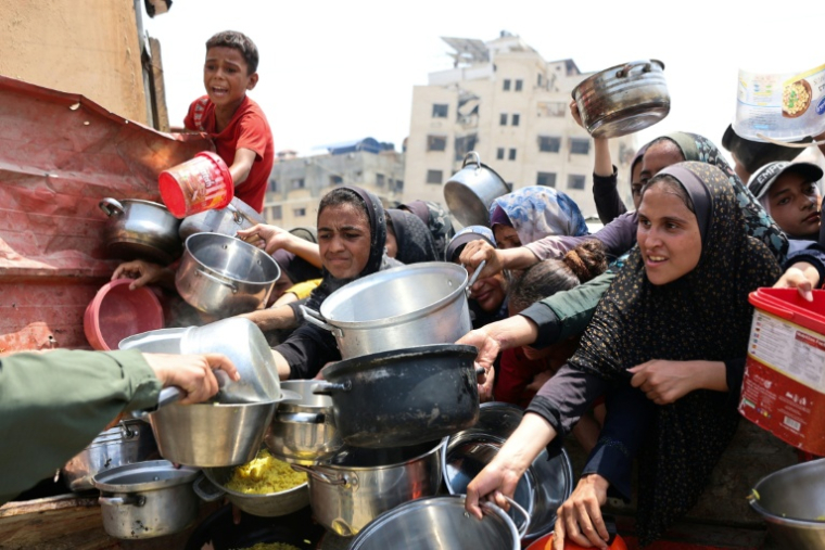 Des Palestiniens tentent de recevoir de la nourriture lors d'une distribution à Gaza le 13 août 2025 ( AFP / Omar AL-QATTAA )