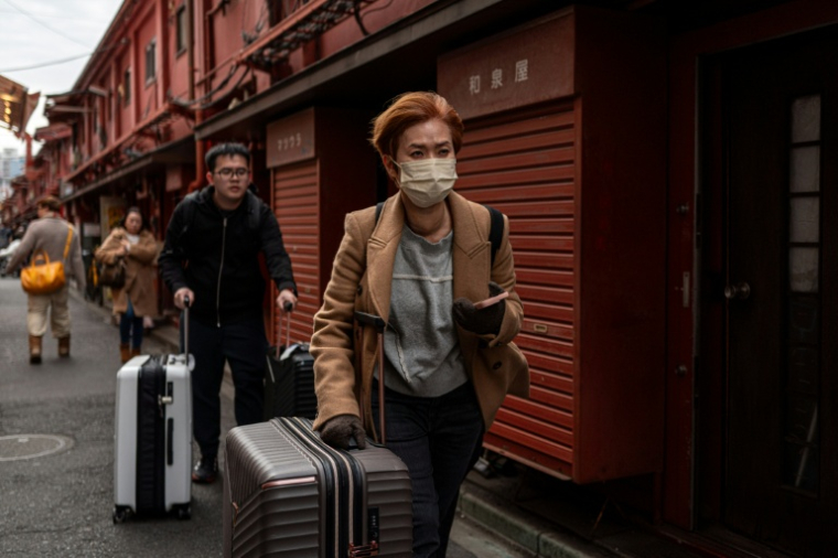 Des touristes dans une rue commerçante du quartier d'Asakusa, près du temple Sensoji, un lieu touristique populaire de Tokyo, le 20 janvier 2026 au Japon ( AFP / Philip FONG )
