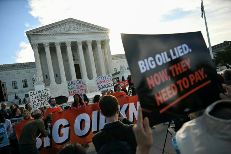 Des personnes manifestent pour dénoncer la contribution des compagnies pétrolières au changement climatique devant la Cour suprême des Etats-Unis, à Washington le 5 octobre 2026 ( AFP / Jim WATSON )